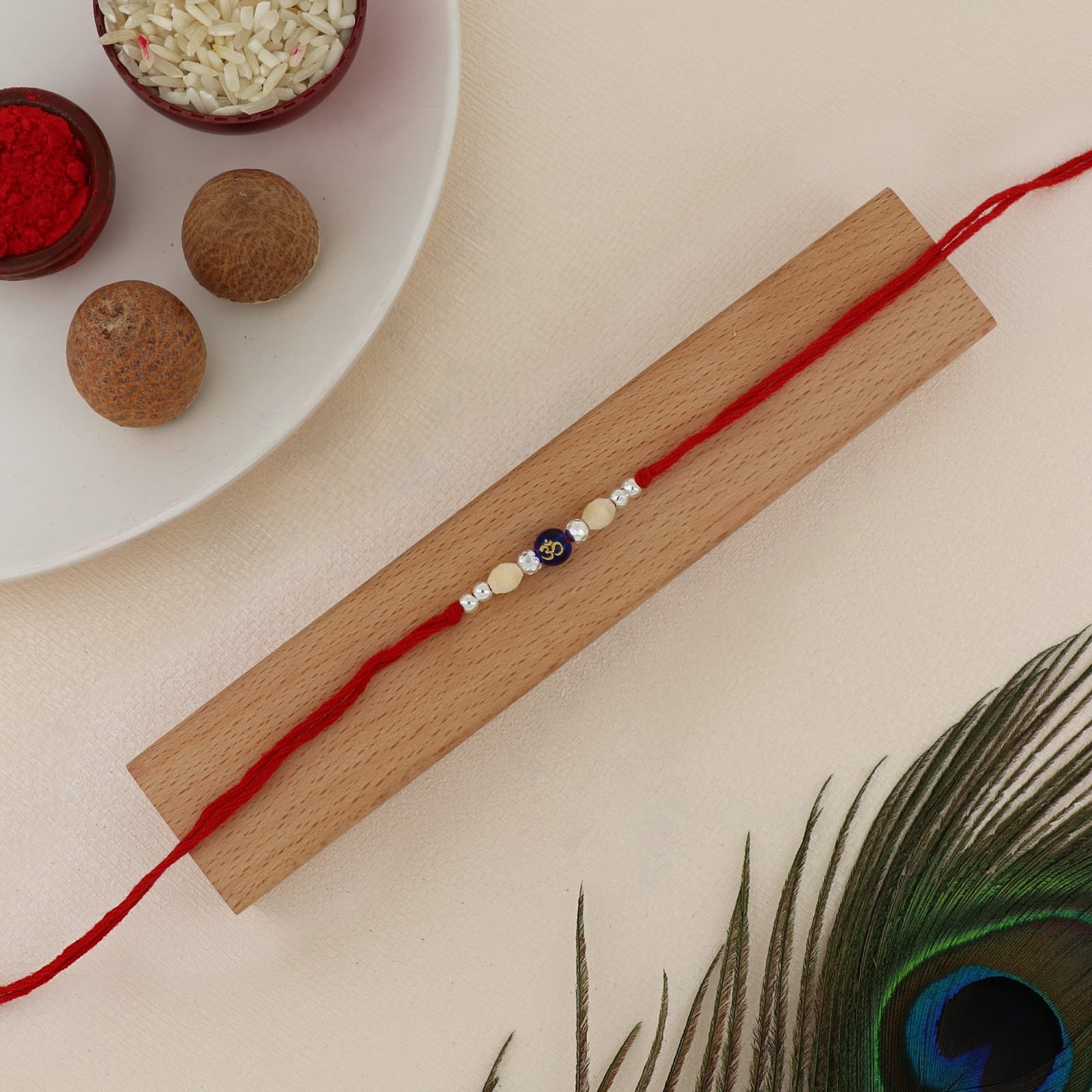 Silver Om Bead Rakhi | Sacred Om Bead with Wooden, Crystal & Silver Accents | Adjustable Red Thread