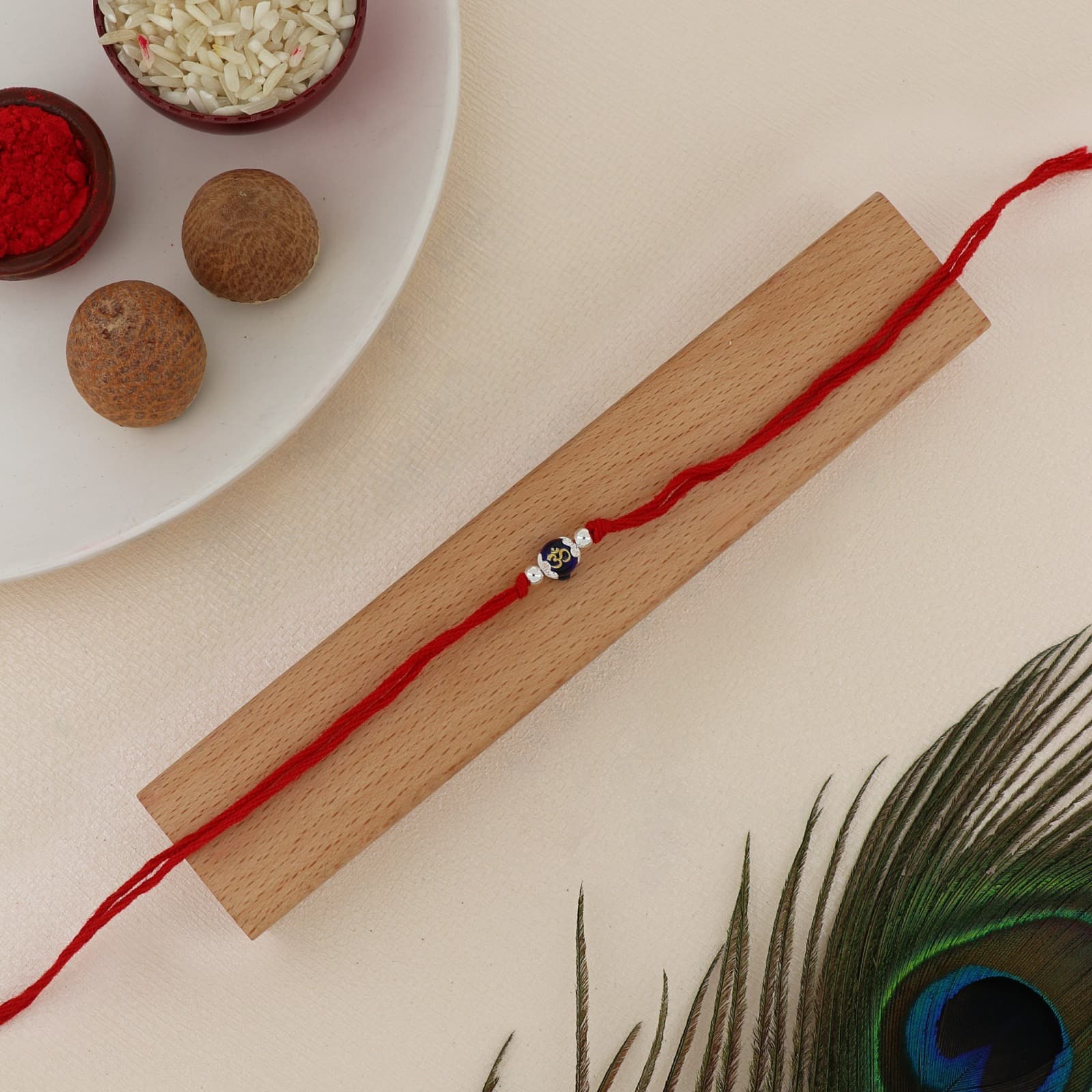 Silver Om Rakhi | Auspicious Om Charm with Silver Accents | Adjustable Red Thread