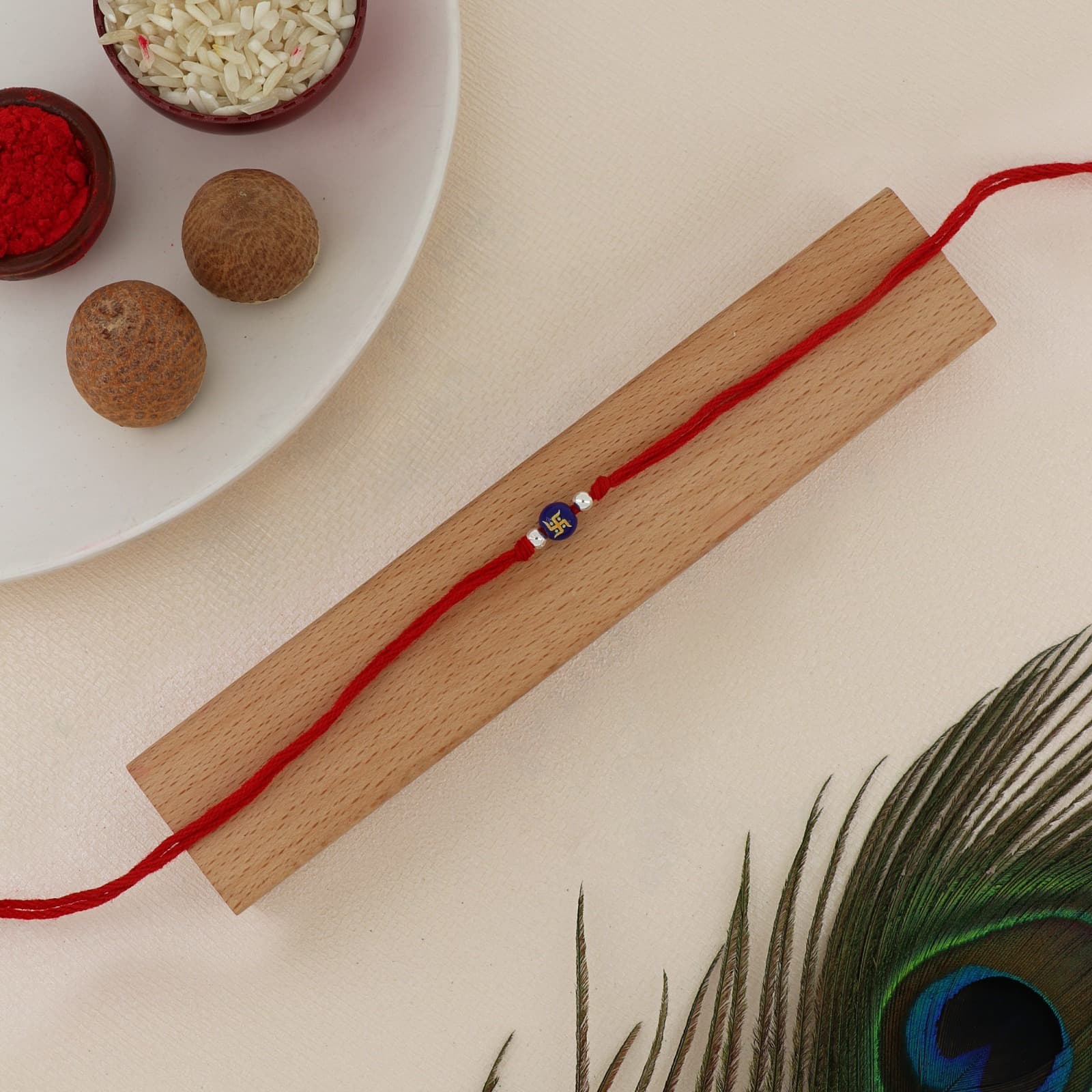 Silver Swastik Rakhi | Auspicious Swastik Charm with Silver Accents | Adjustable Red Thread